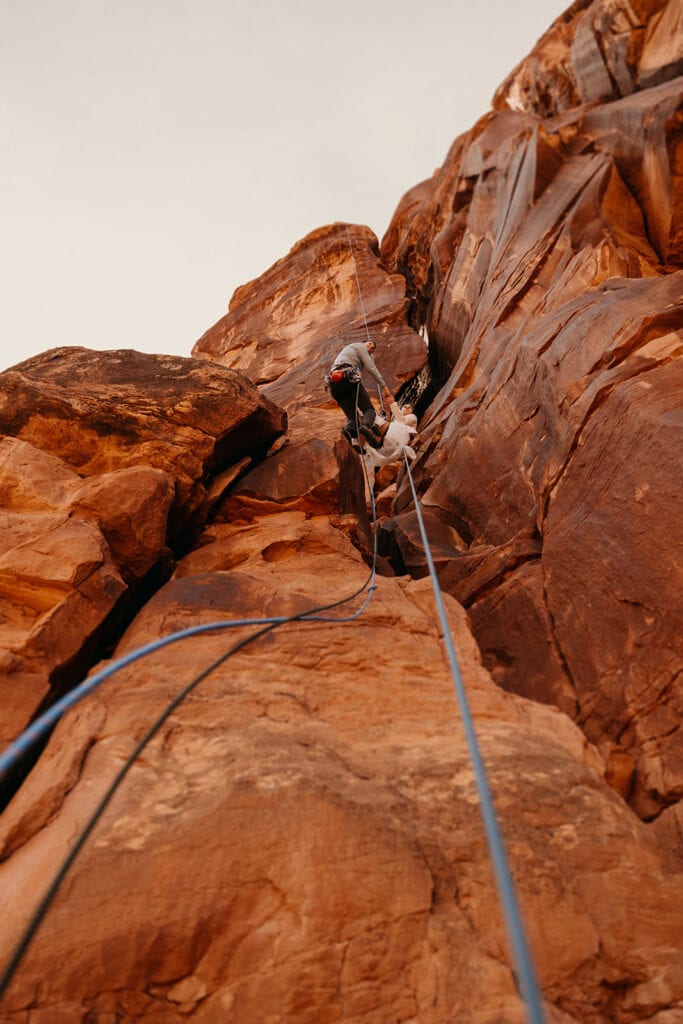 The bride and groom rappel down the route together.