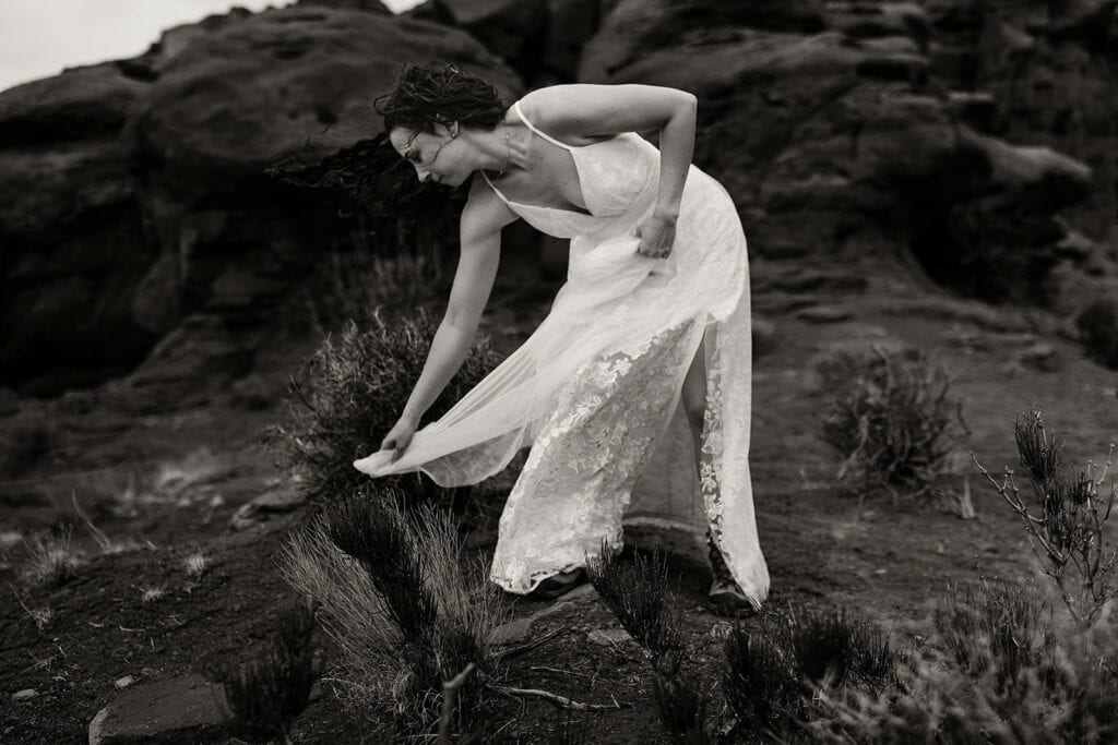 The bride gets her dress stuck off of a pricky bush.