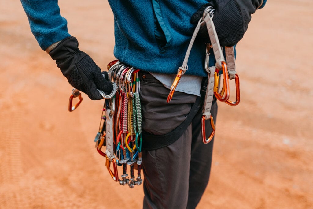 The groom puts his rack on his harness.