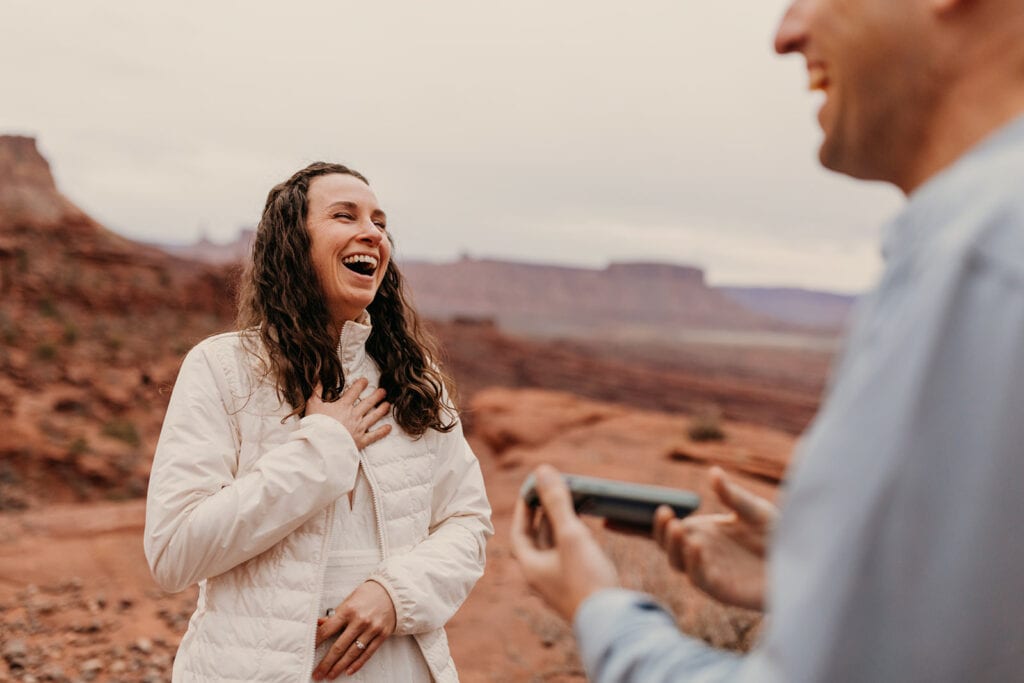 The bride laughs at a joke the groom said.