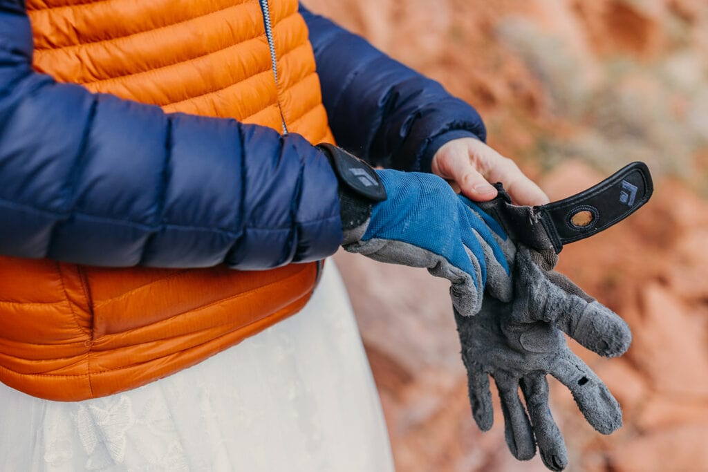 The bride puts on her gloves for belay that the groom gave her on her first date.