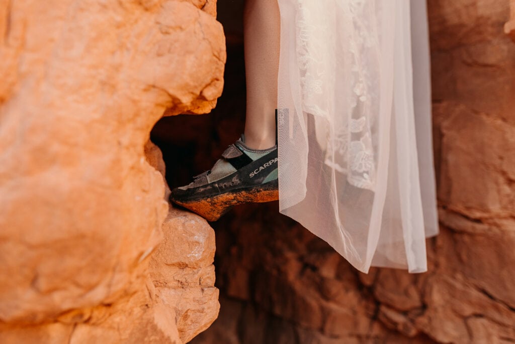 A detail photo of the brides dress + climbing shoes.