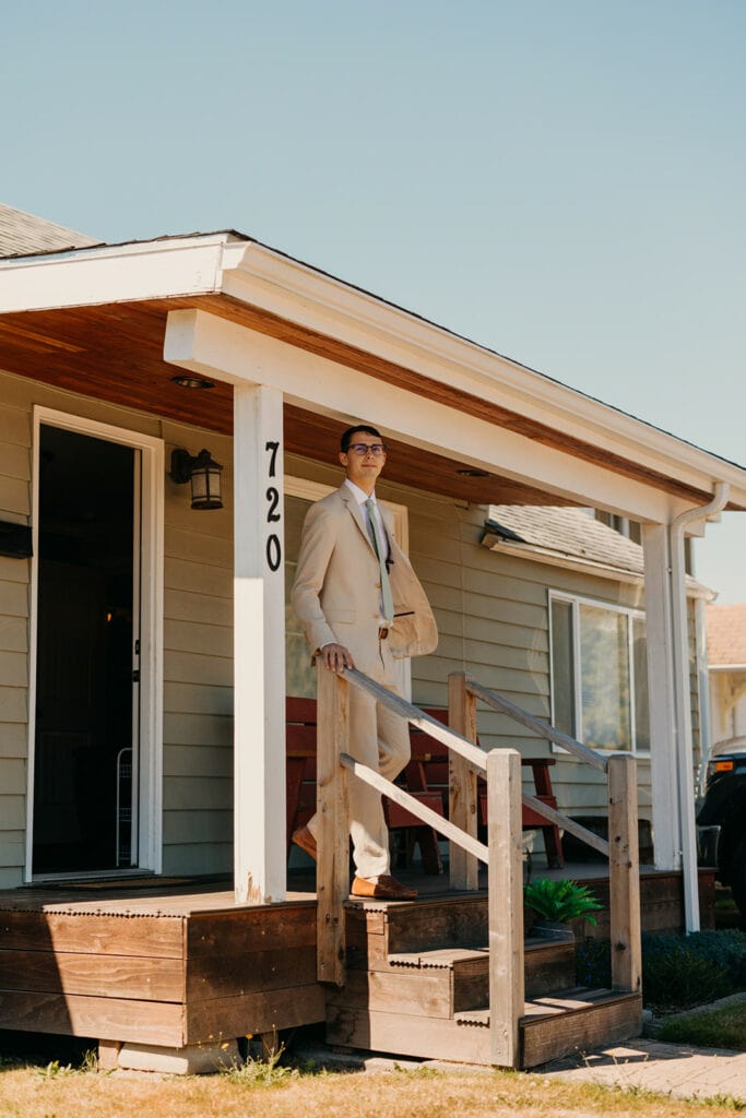 The groom walks off of the porch out to his first look.