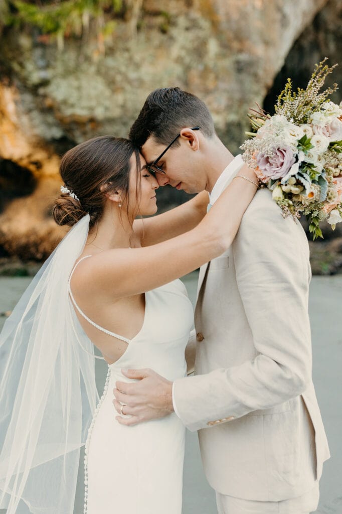 The bride and groom share a quiet moment on the beach together.