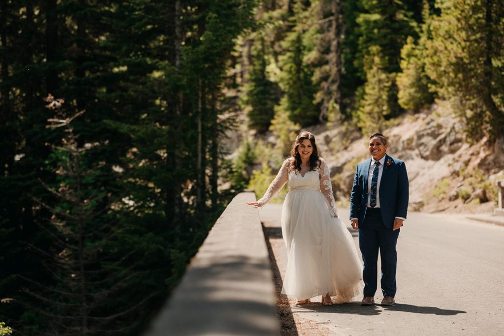The couple walks along the bridge smiling together. 