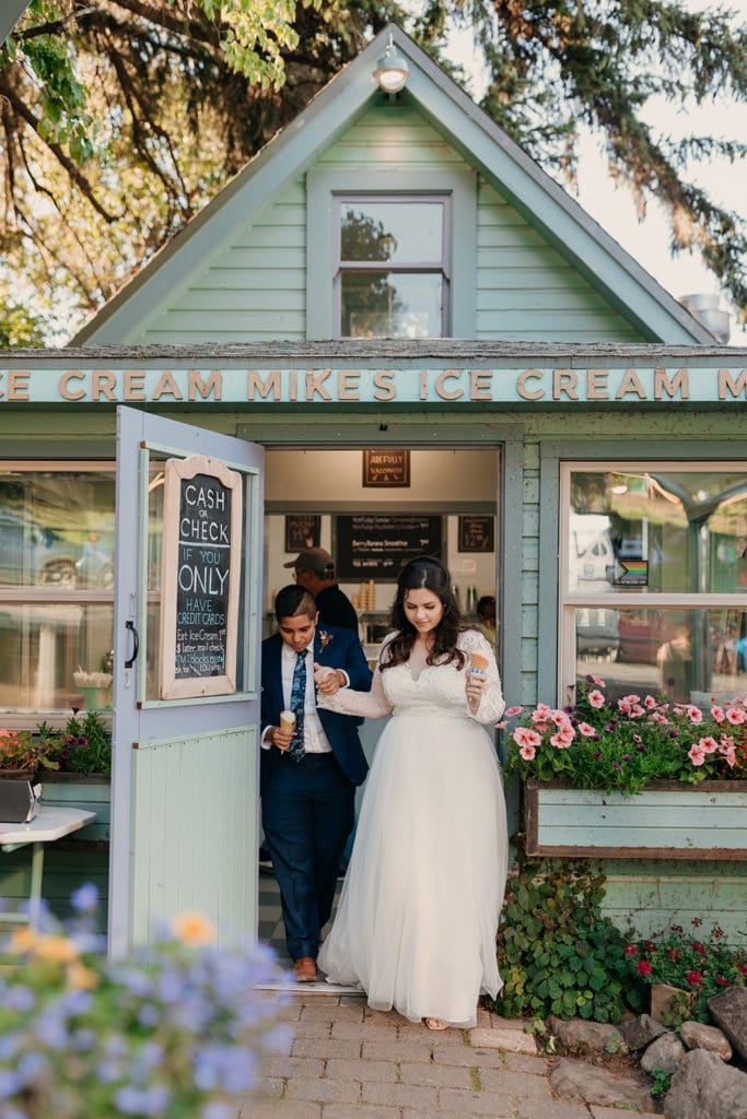 The wedding couple walks out of Mike's Ice Cream together holding hands in Hood River. 