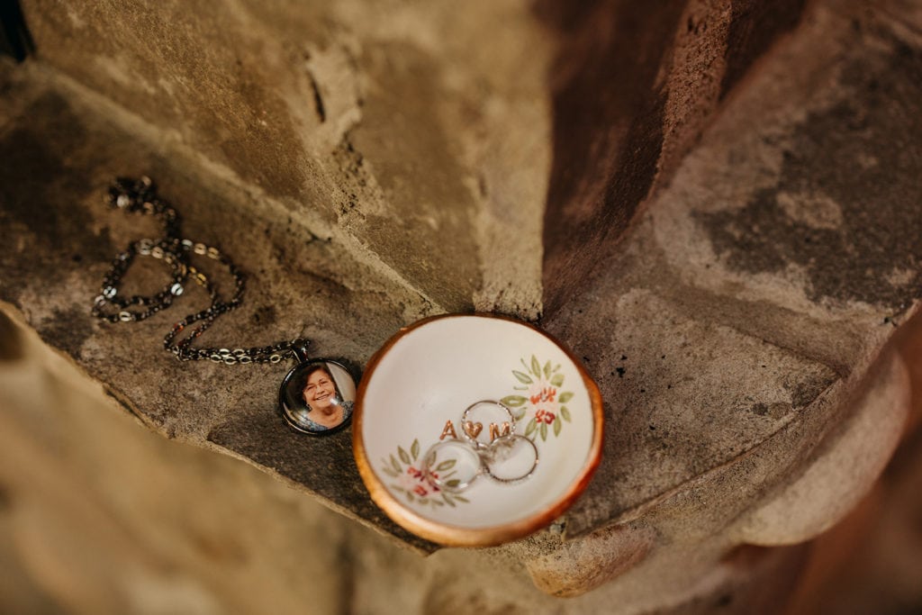 The couple's wedding rings and bride's necklace on the fire place of the cabin. 