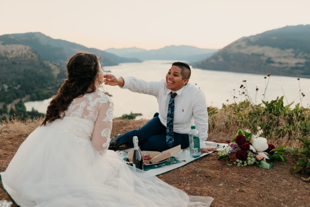 The brides share a fun picnic overlooking the river. 