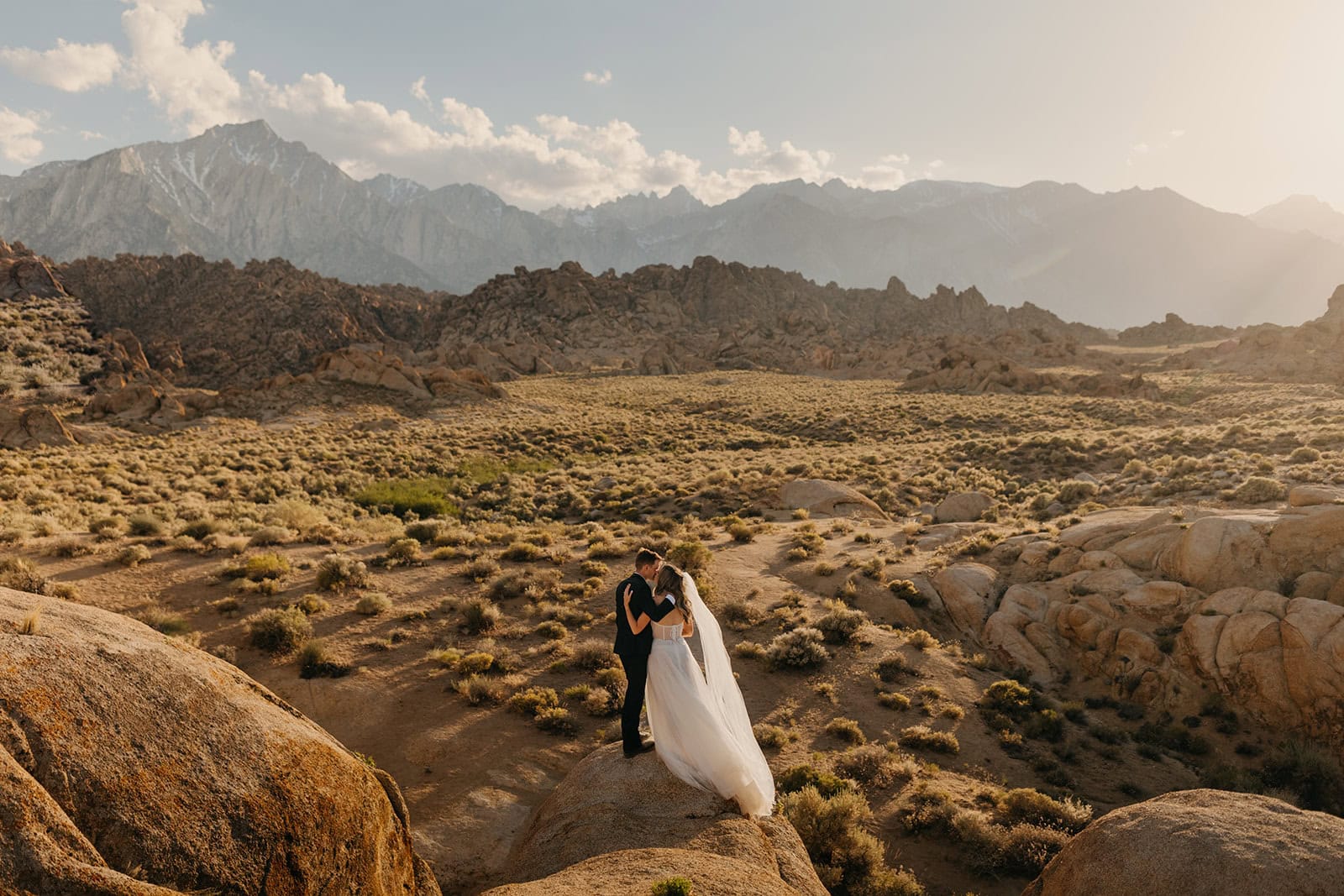 A couple shares a kiss at sunset in Alabama Hills.