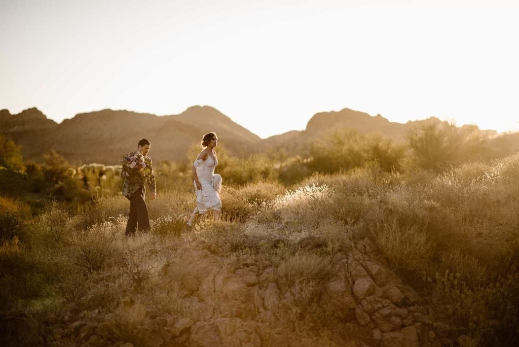 A man and woman walk through the desert together.