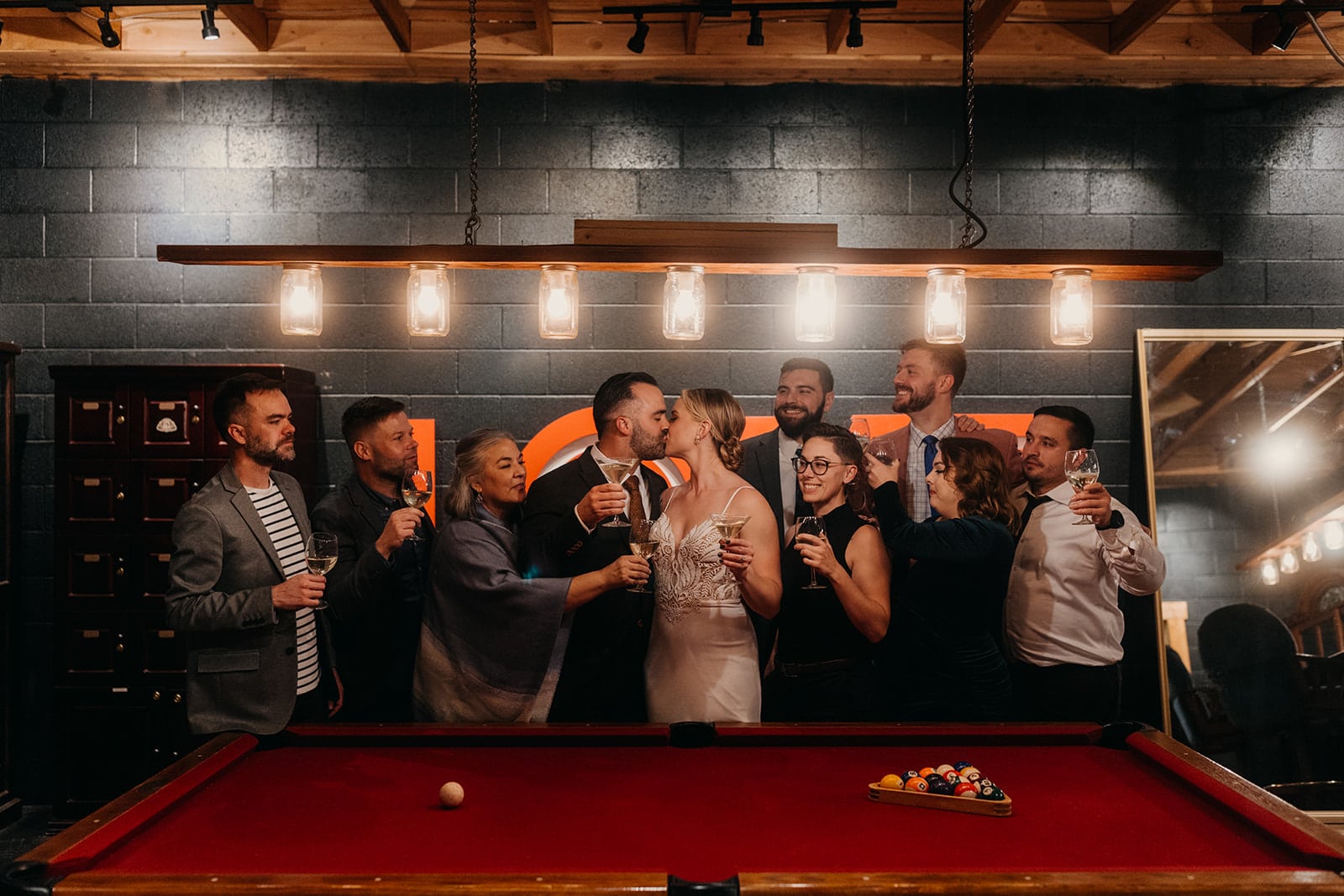 A couple shares a kiss surrounded by their loved ones as they celebrate their union.