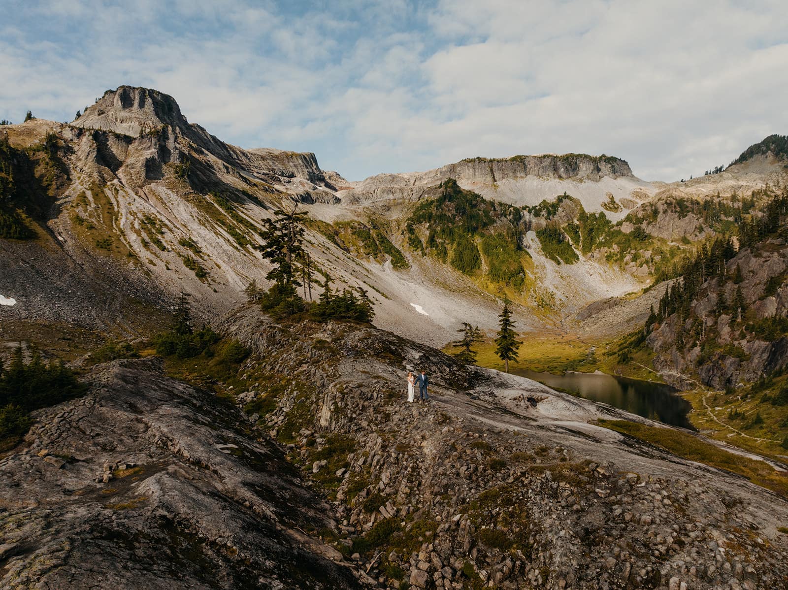 A drone photo of the couple hiking in the mountains.