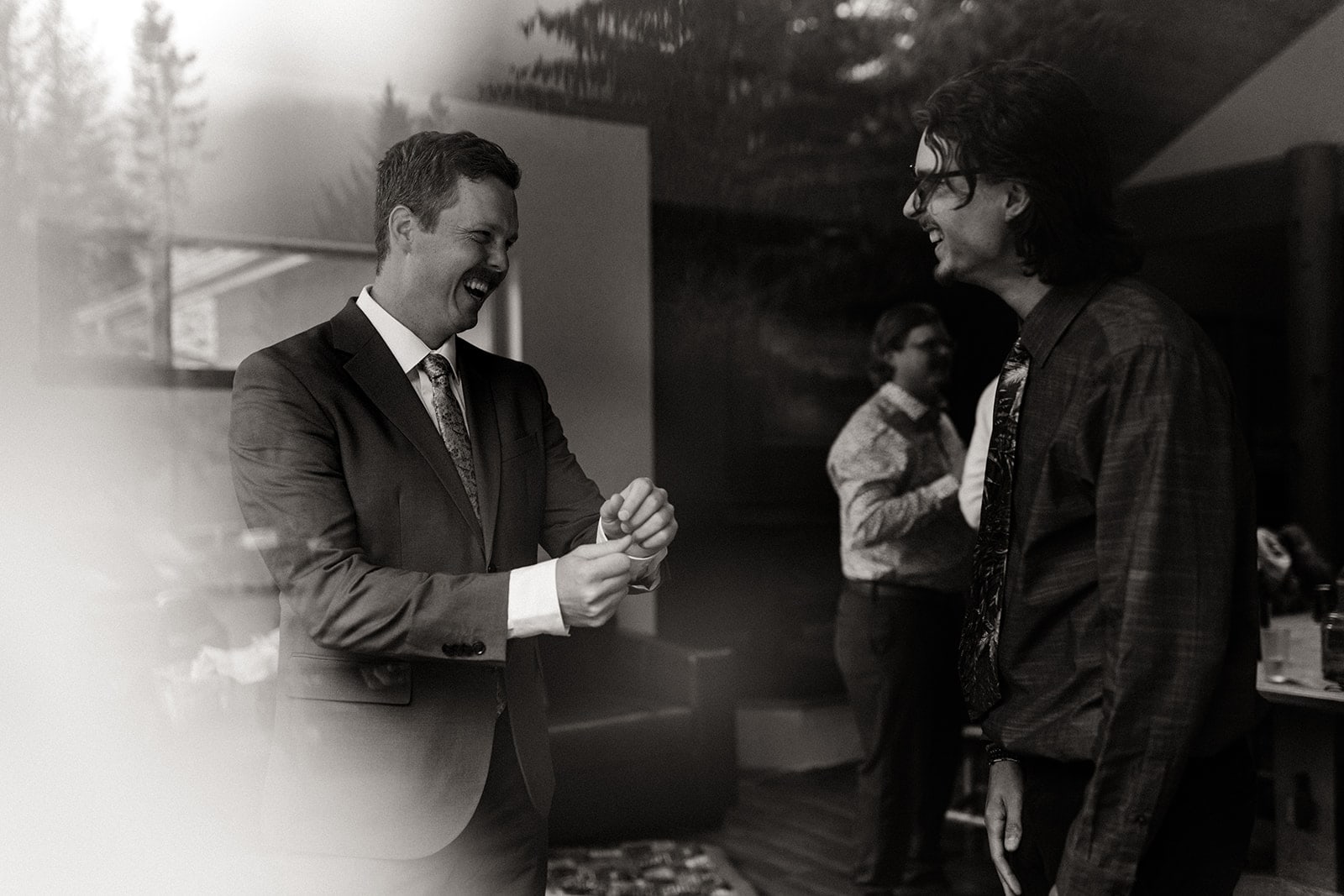 The groom gets ready while smiling at his brother.