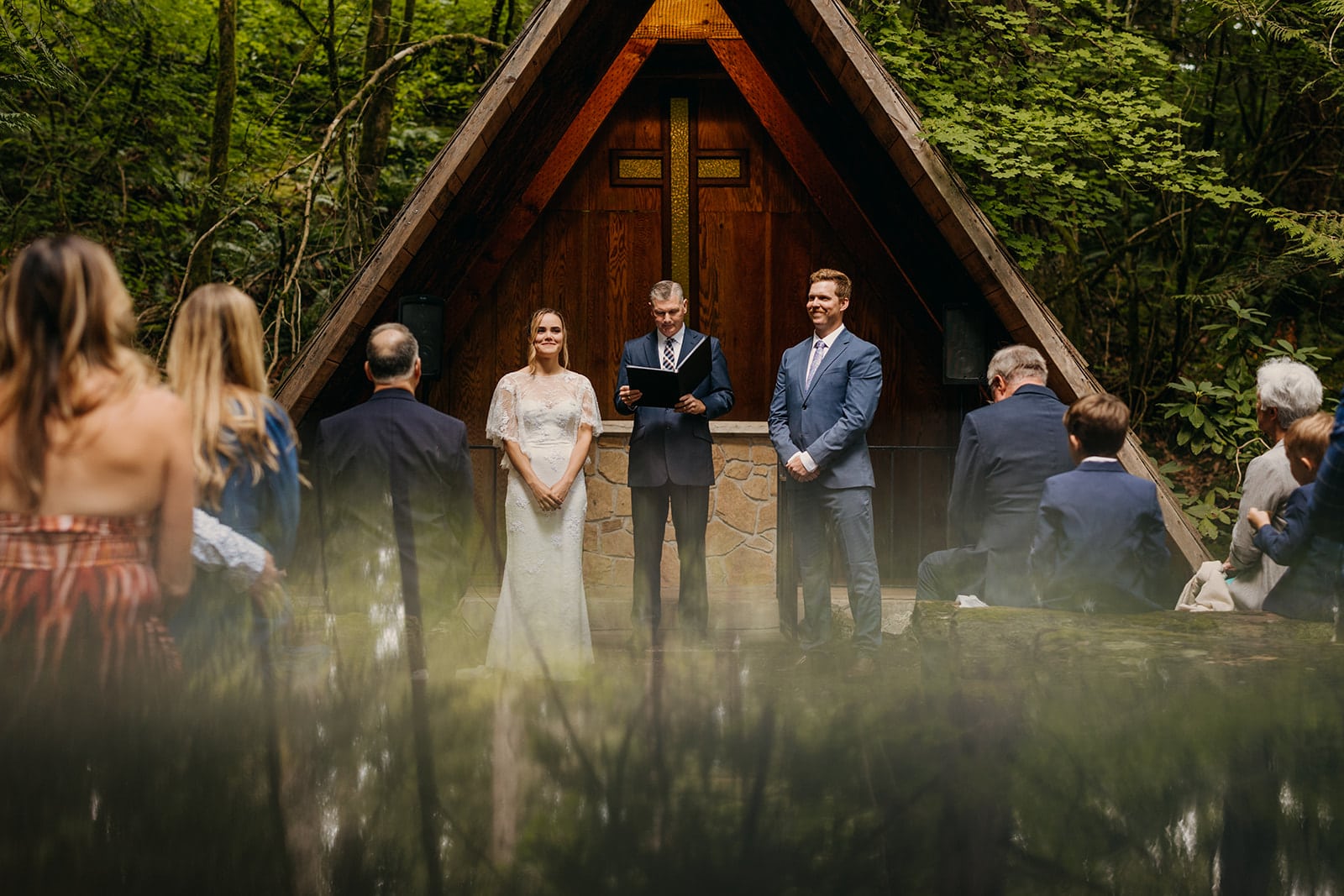 The couple looks at their guests as the officiant speaks. 
