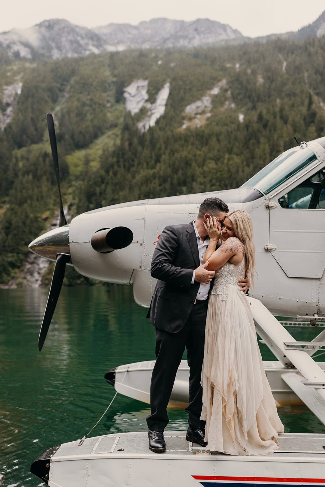 A couple shares a cute intimate moment on the side of a seaplane.
