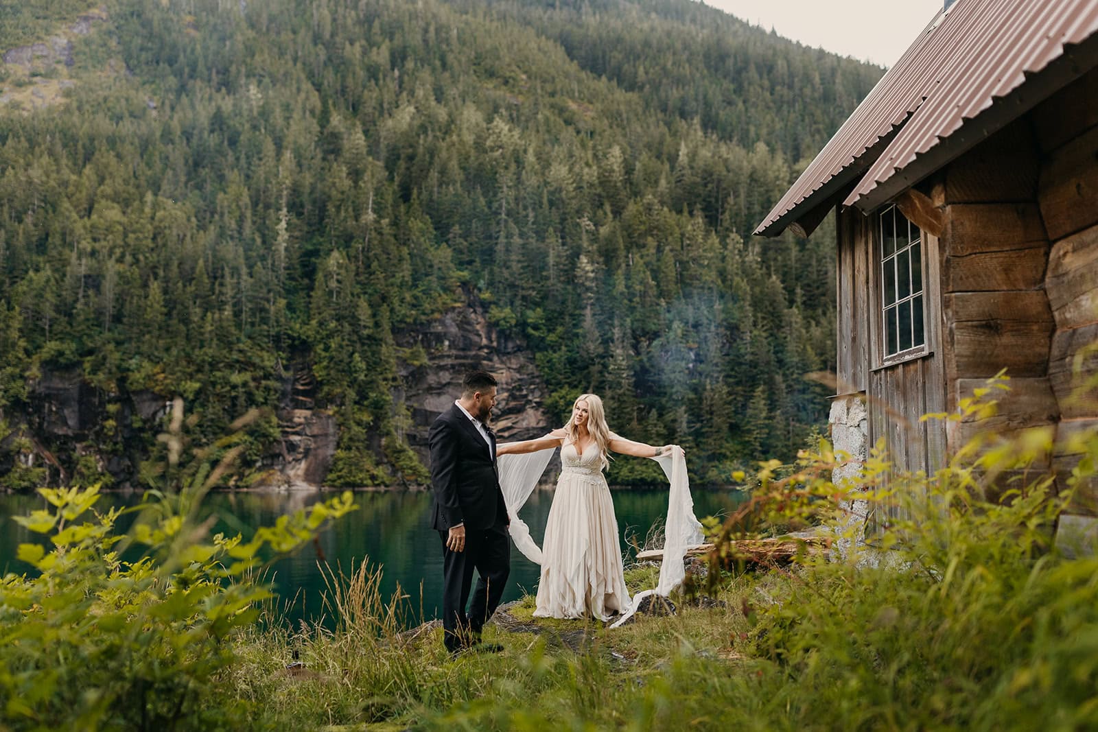 A bride shows her dress off to her groom during their first look.