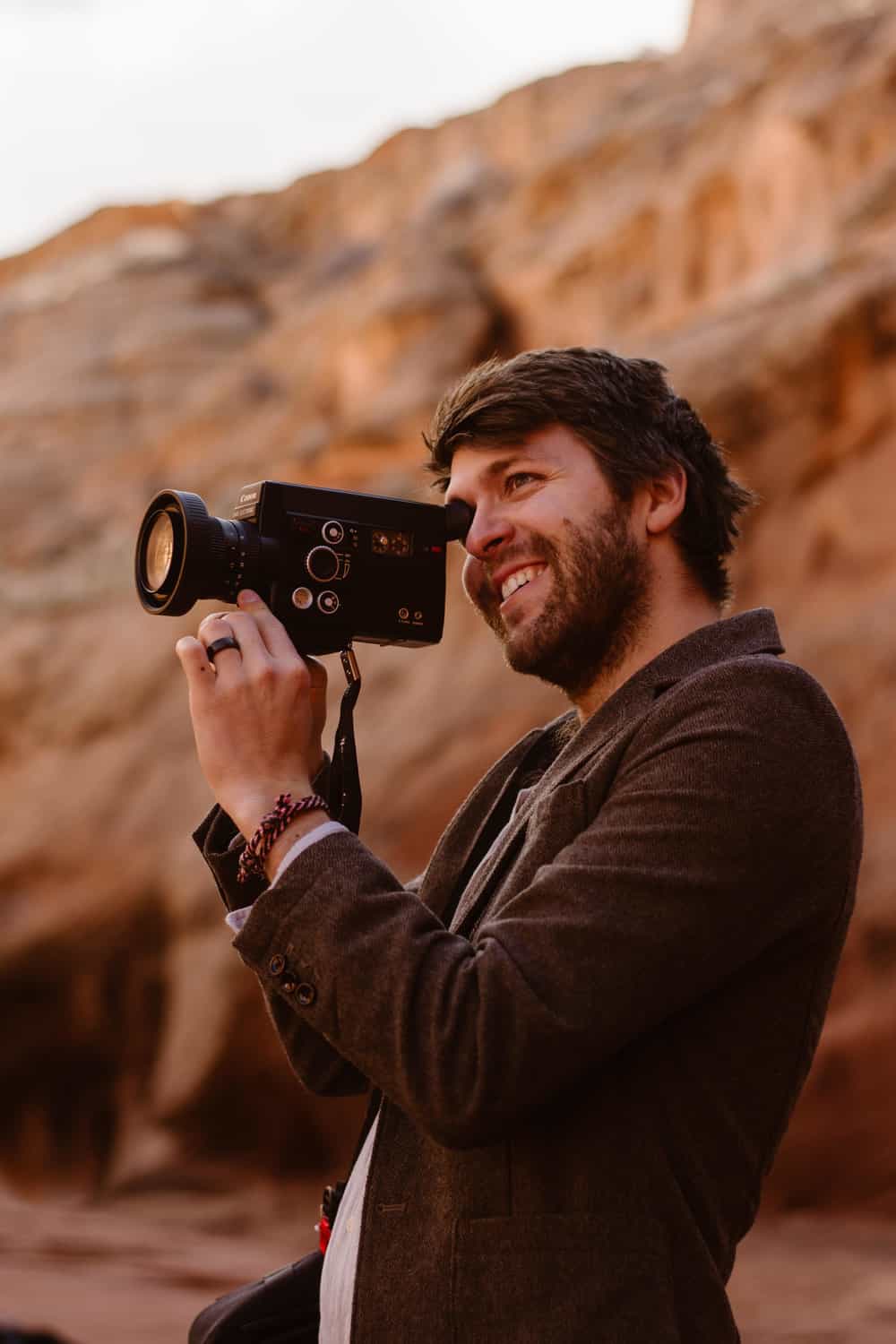 A groom films his bride on a super 8 video camera.
