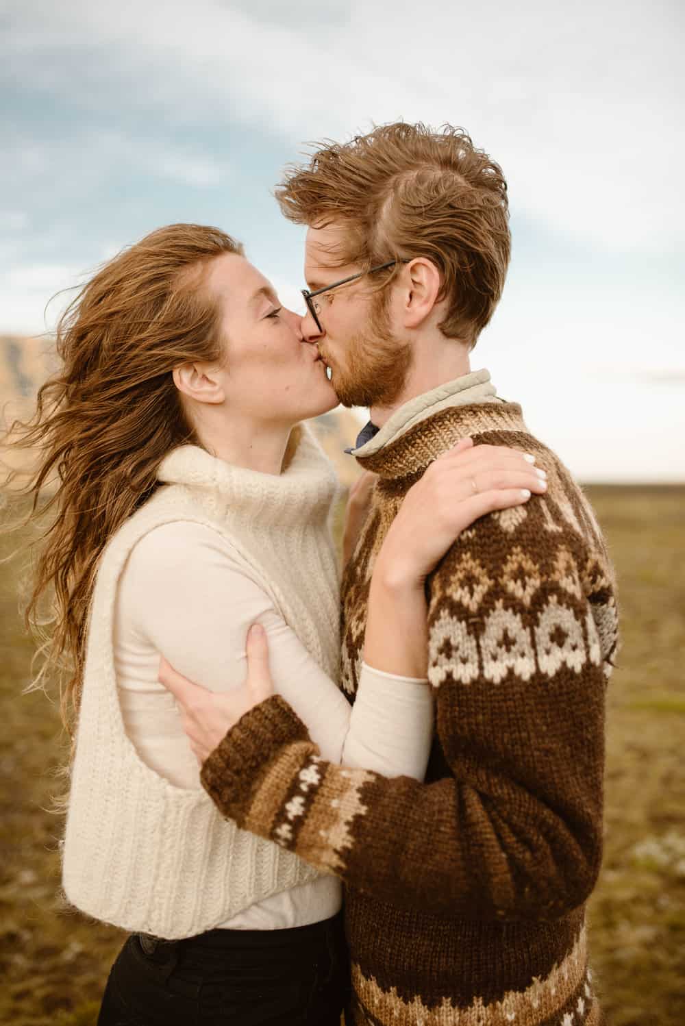 The couple shares a kiss in the wind.