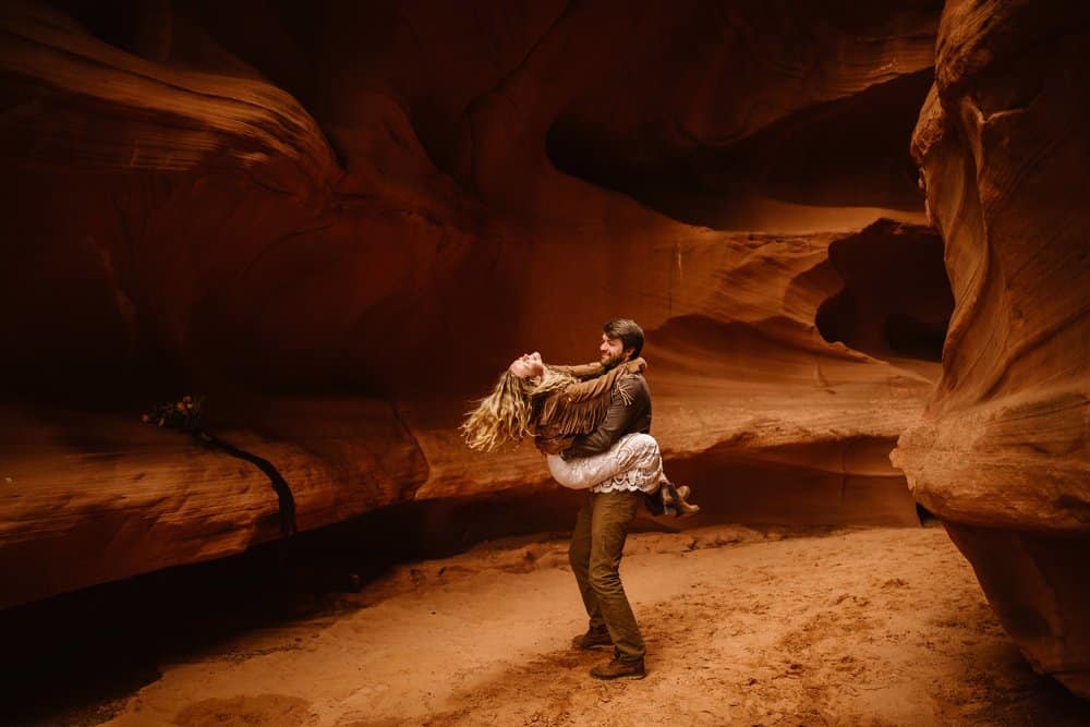A groom holds a bride and spins her around. 