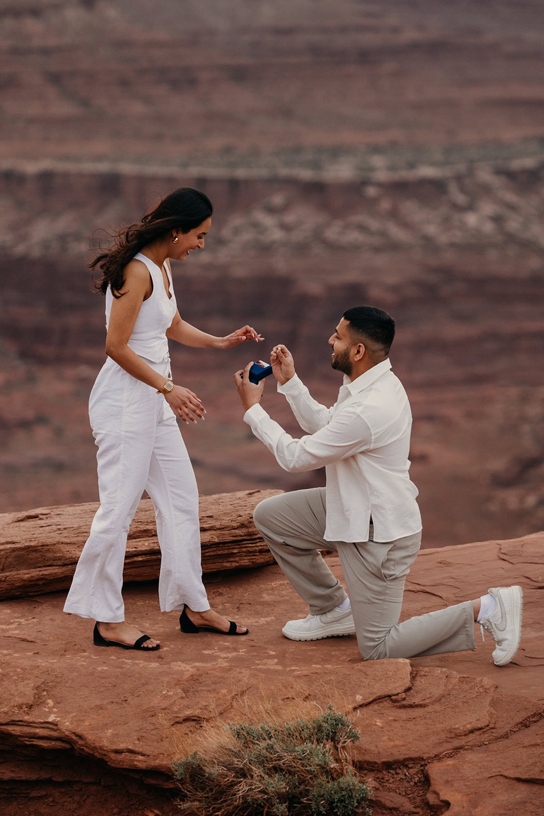 A man proposes to his girlfriend in the desert landscape of Moab, Utah.