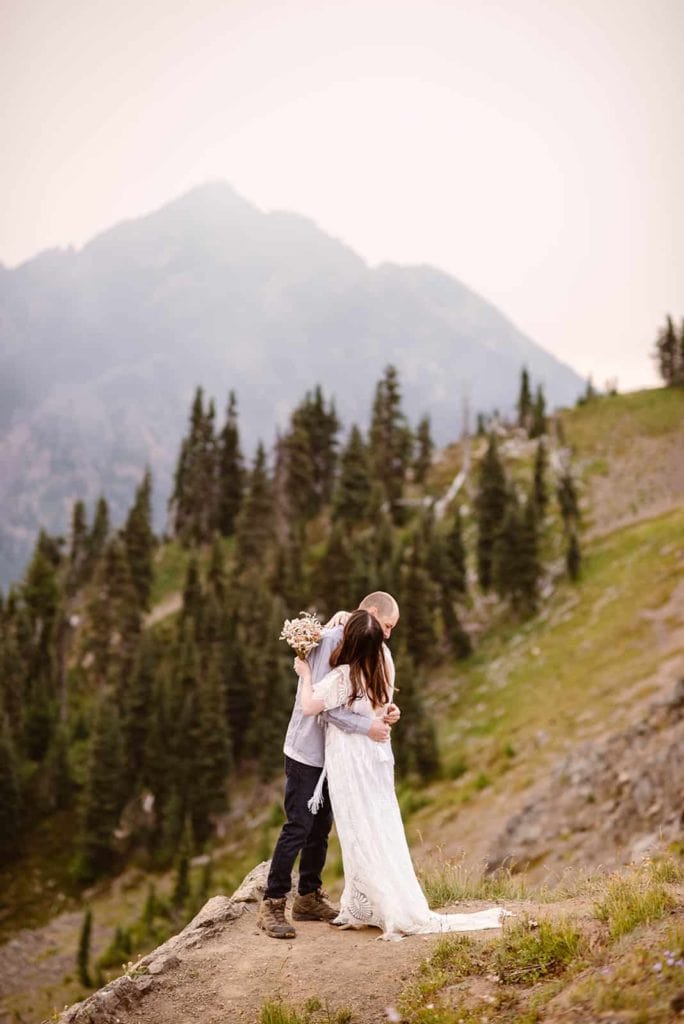 A bride and groom share a first look while out taking in the sunrise at Hurricane ridge with vast mountain views.