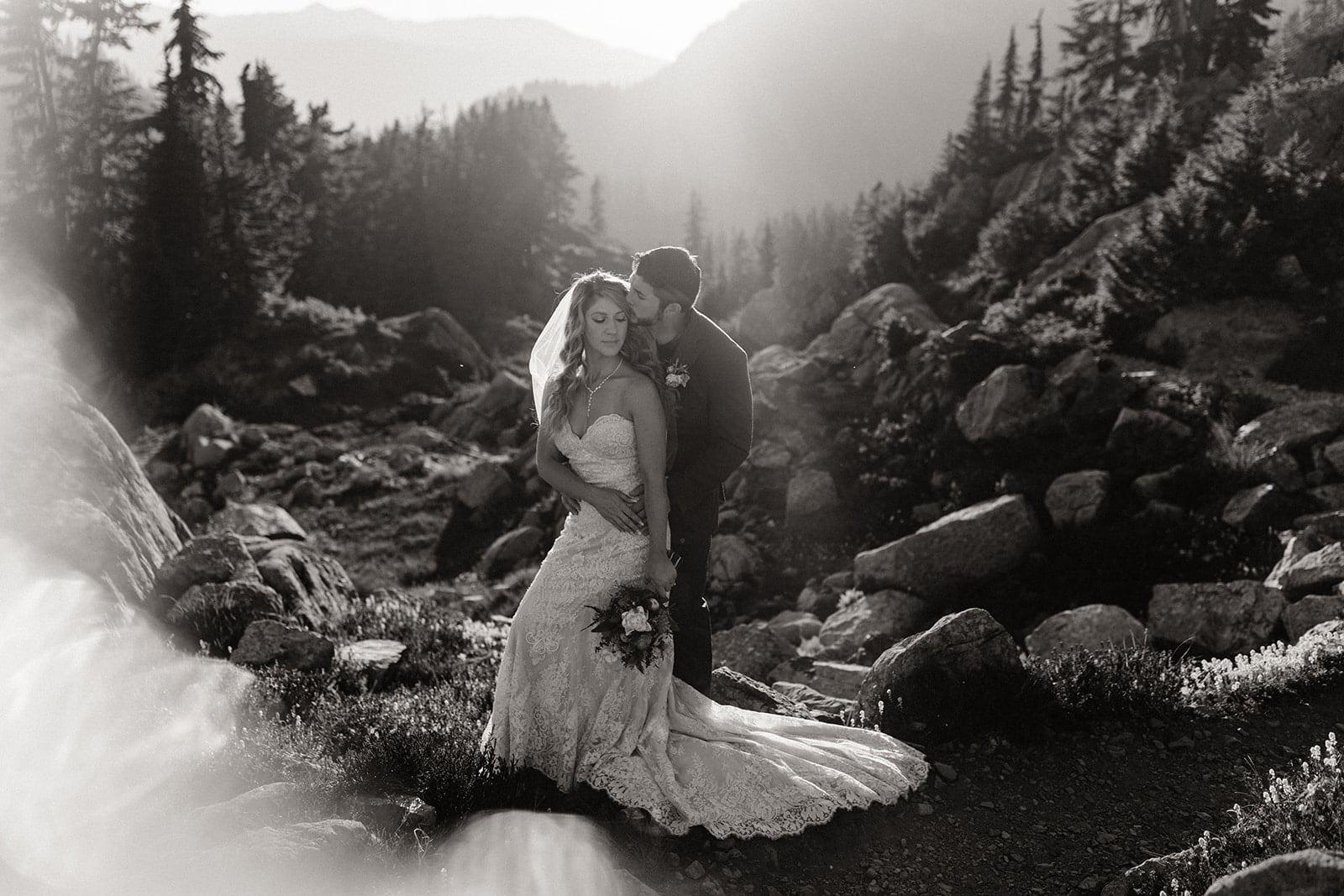 The couple stands for a backlit portrait.