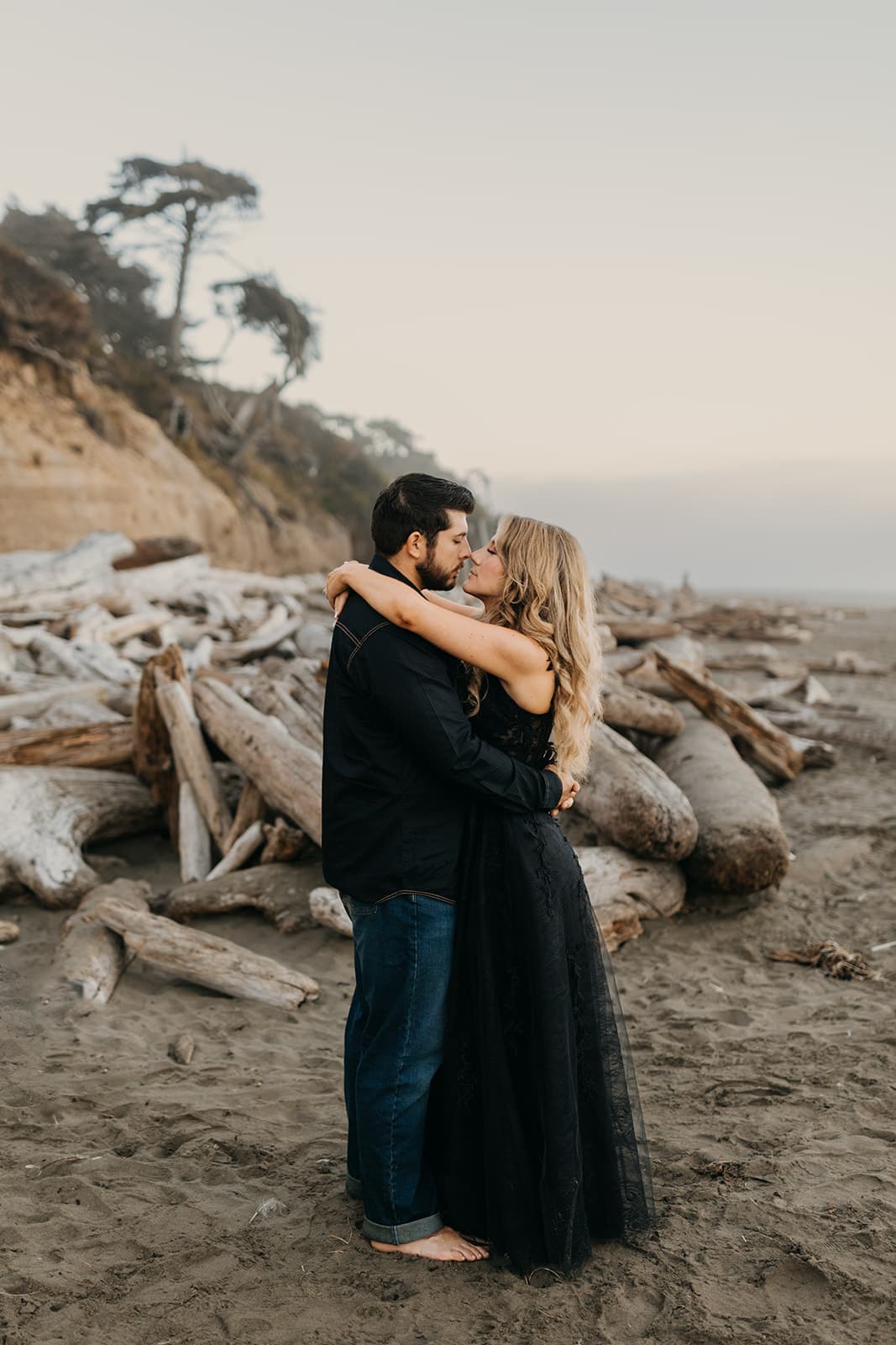 The couple holds each other at sunrise on the beach. 
