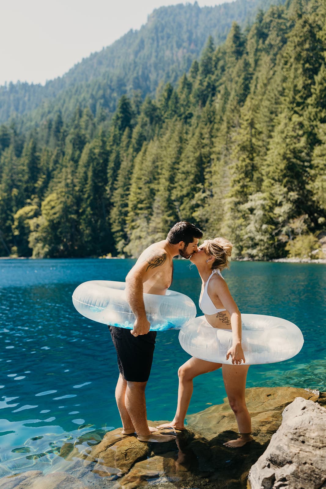 The couple shares a kiss by the lake. 