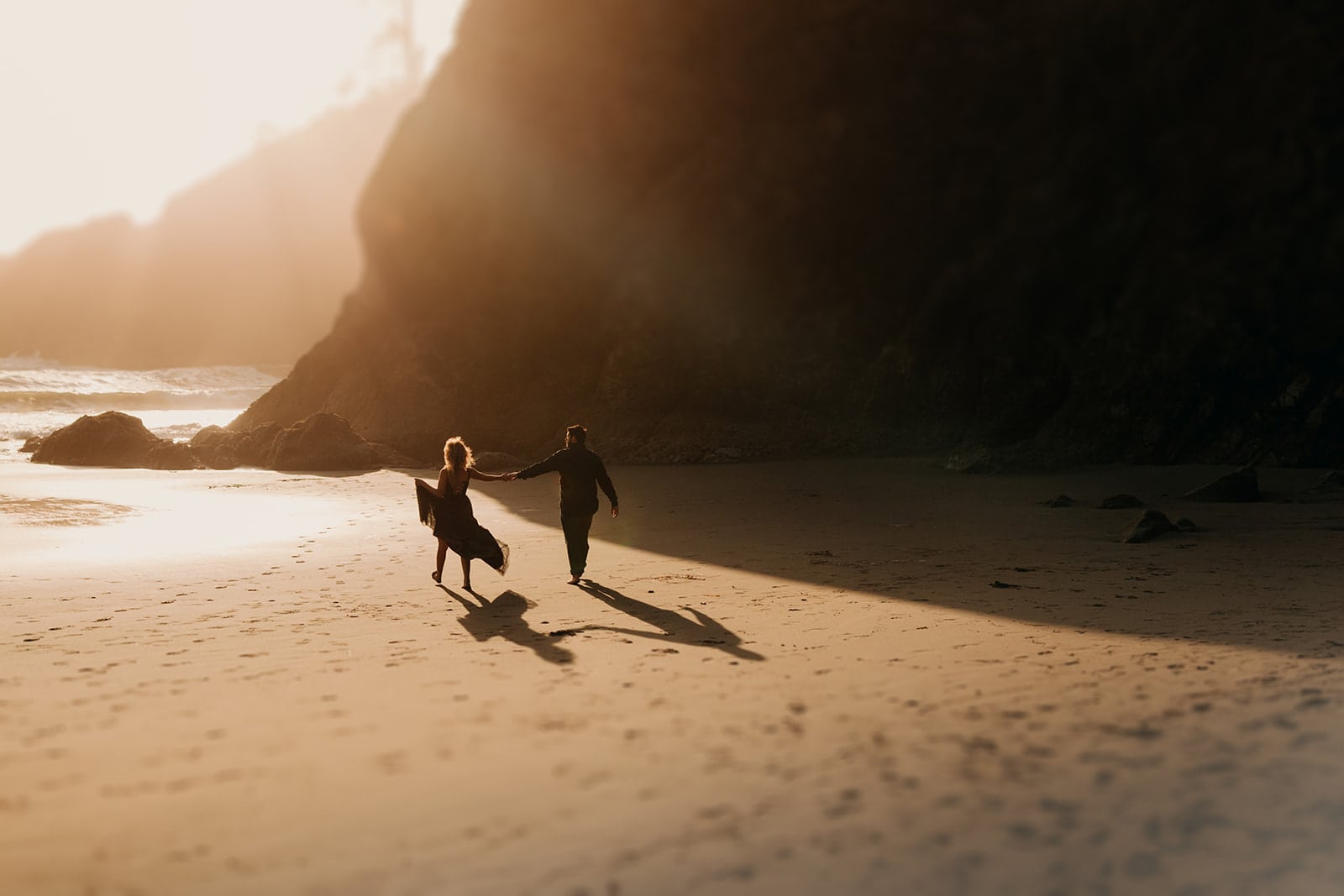 A couple runs on the coast together at sunset.
