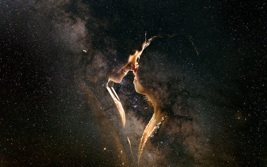 A couple double exposed with the milky way night sky.