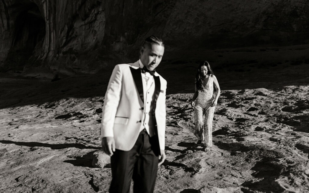 The couple walks together through the desert.