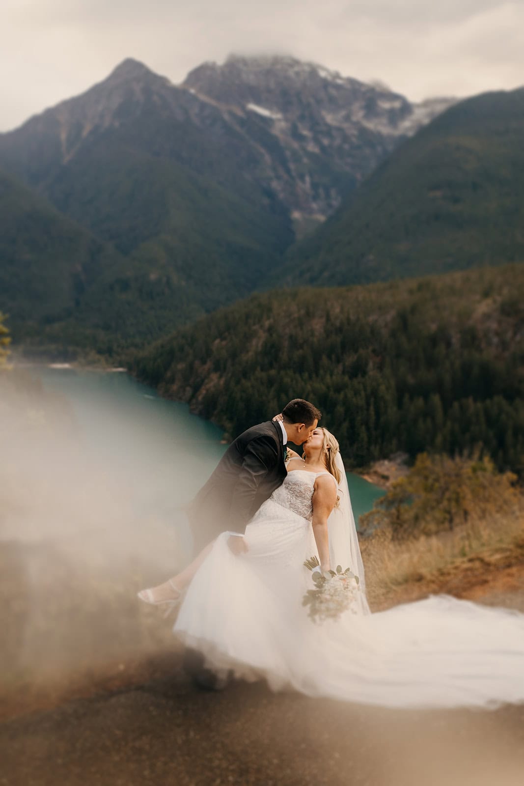 A couple shares a passionate kiss at Diablo Lake overlook.