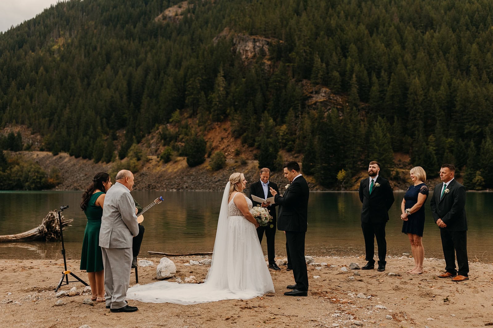 A couple holds their elopement ceremony by Diablo Lake on a fall day.