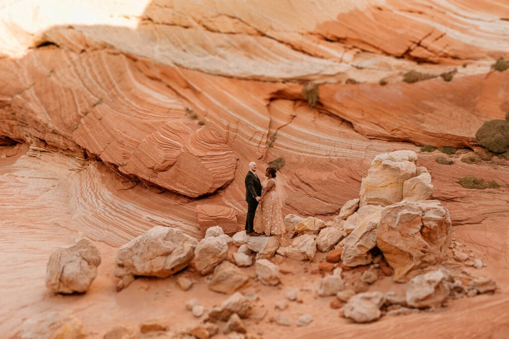 A couple stands among wild rock formations.