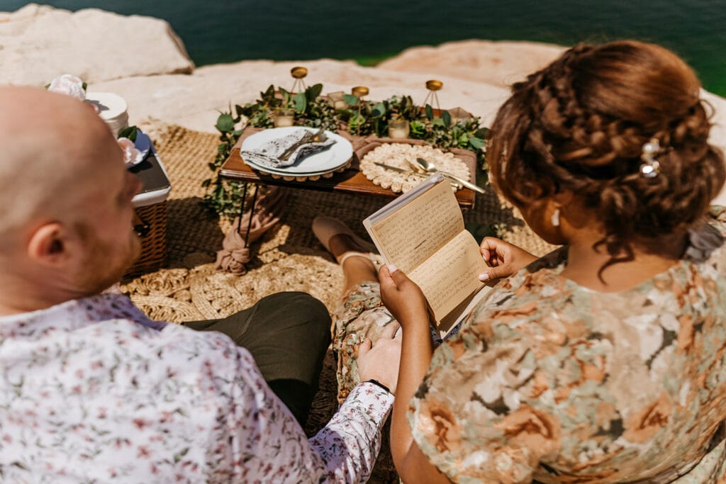 A bride reads letters from the couple's friends at their picnic.