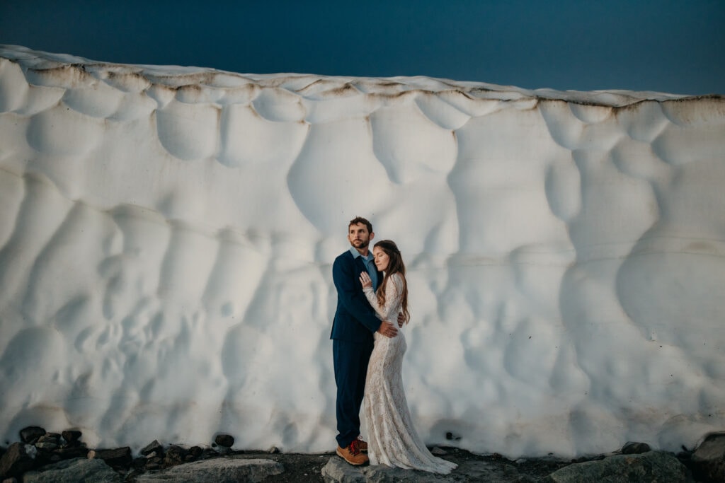 A snowy glacier elopement with a couple at the first light in the morning.