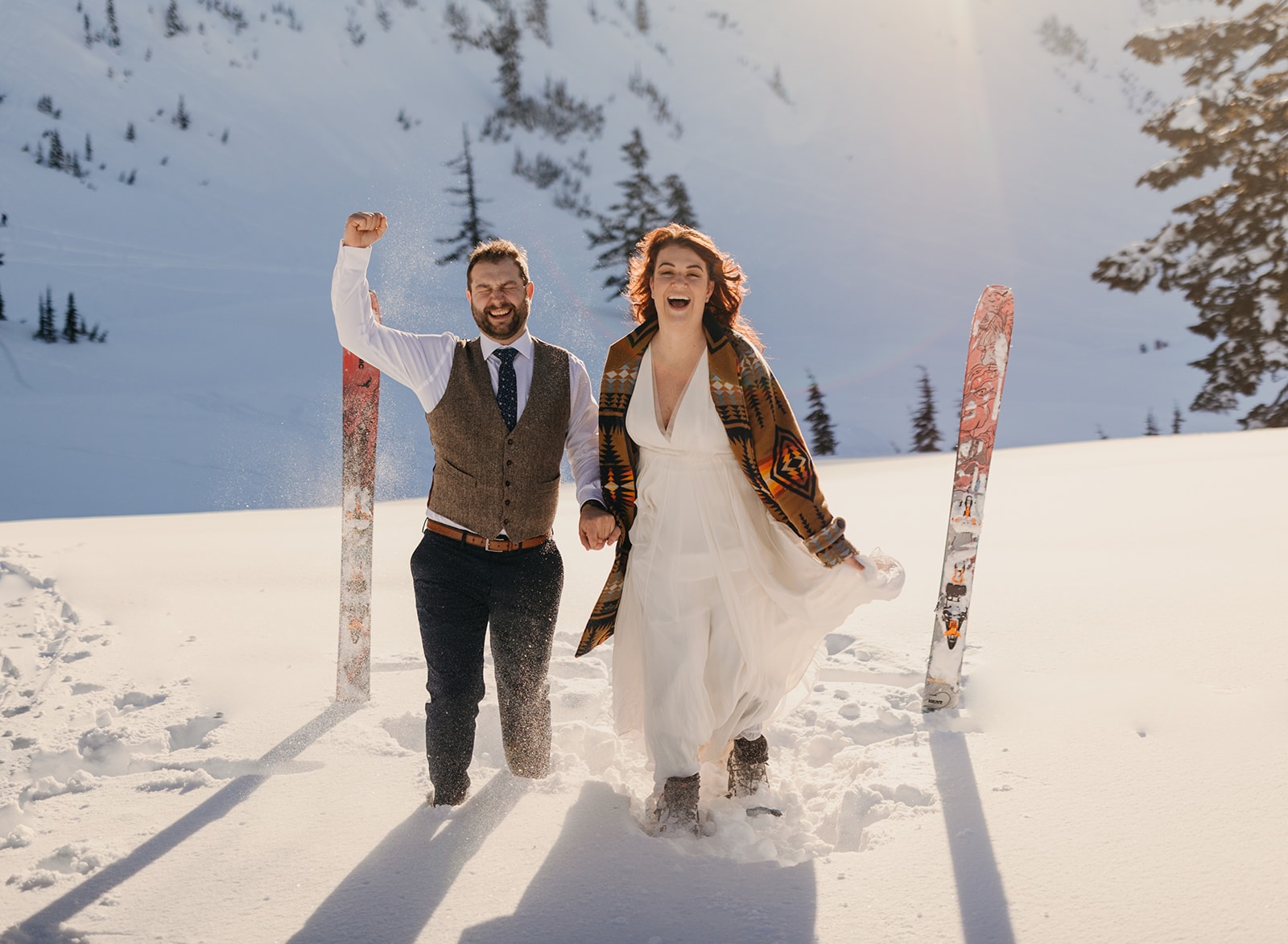 A couple plays in the snow together.