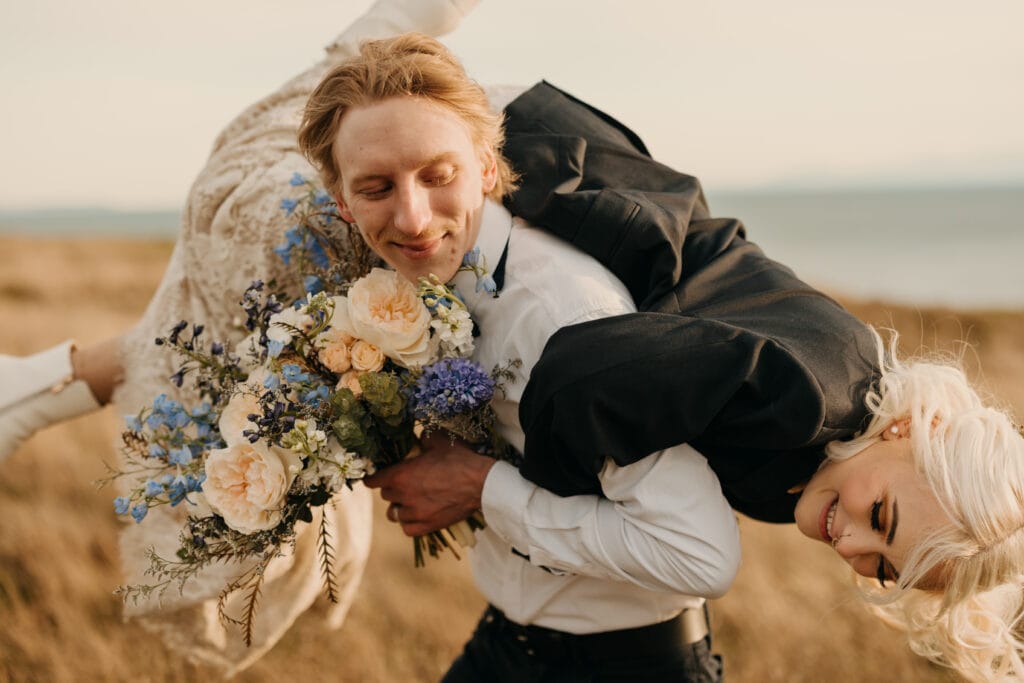 A groom swoops up his bride and talks away with her.