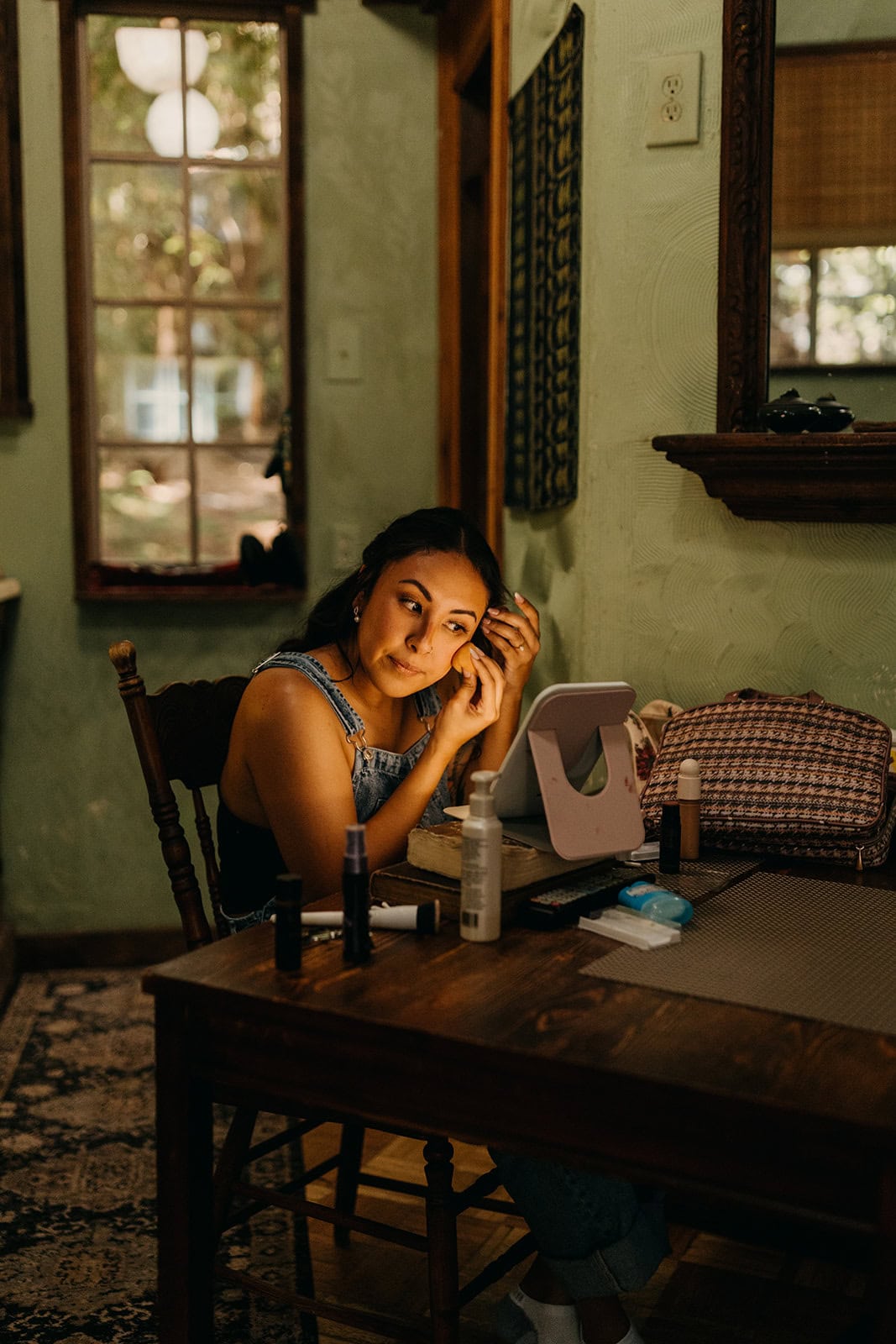 A bride does her makeup as she gets ready for her elopement.