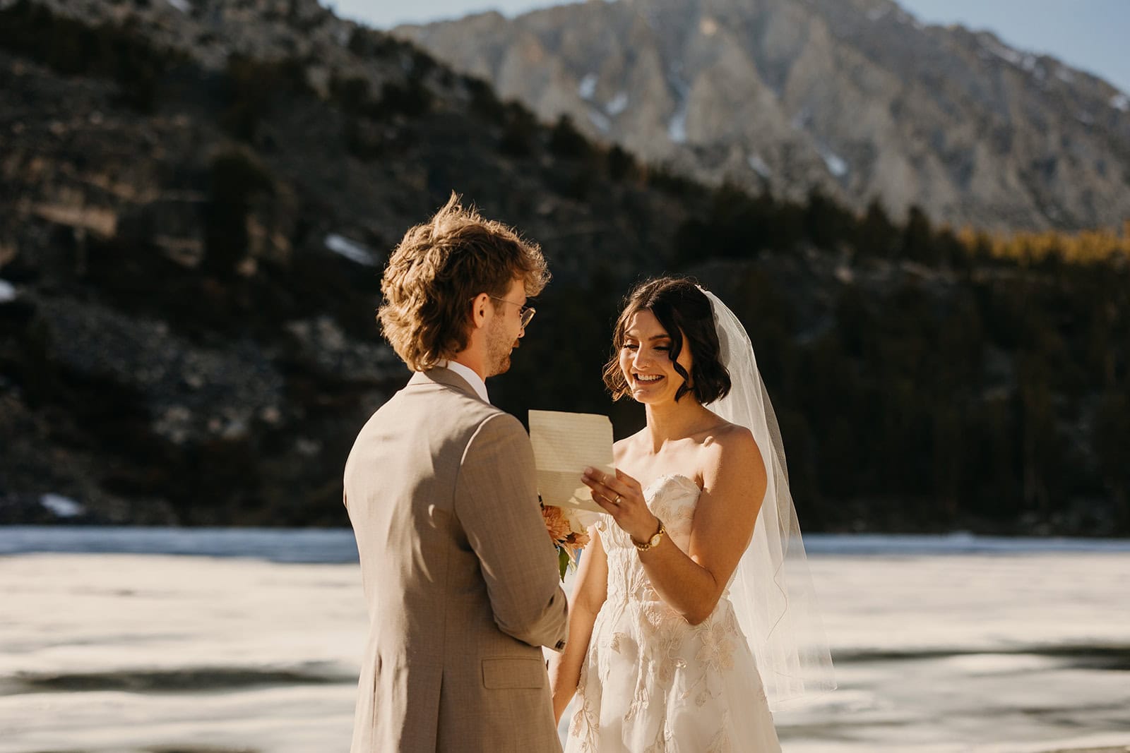 A bride reads her vows to her husband in the mountains.