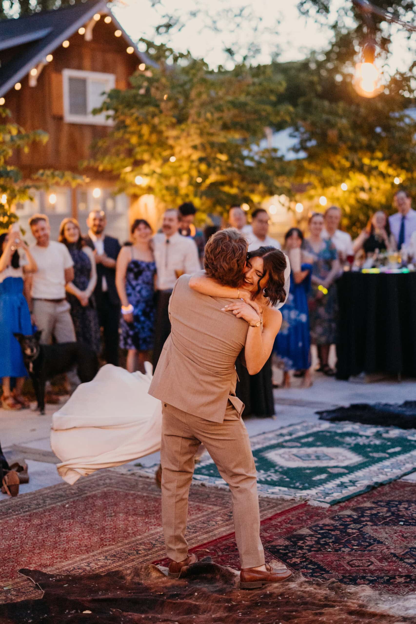 A groom swings his bride around on the dance floor at an elopement party.